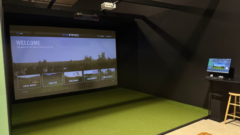 Inside Kenny's Golf Club: simulator bays equipped with launch monitors and swing‑analysis cameras, plus an on‑site snack bar and beverage service.